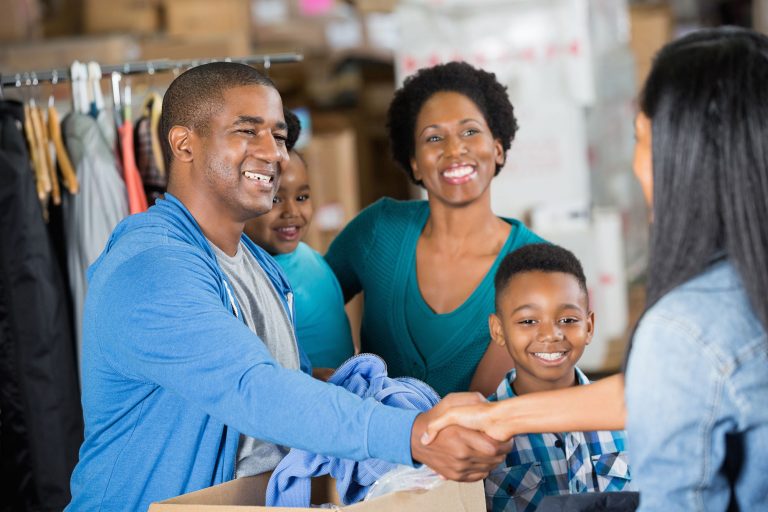 smiling family shaking hands with woman